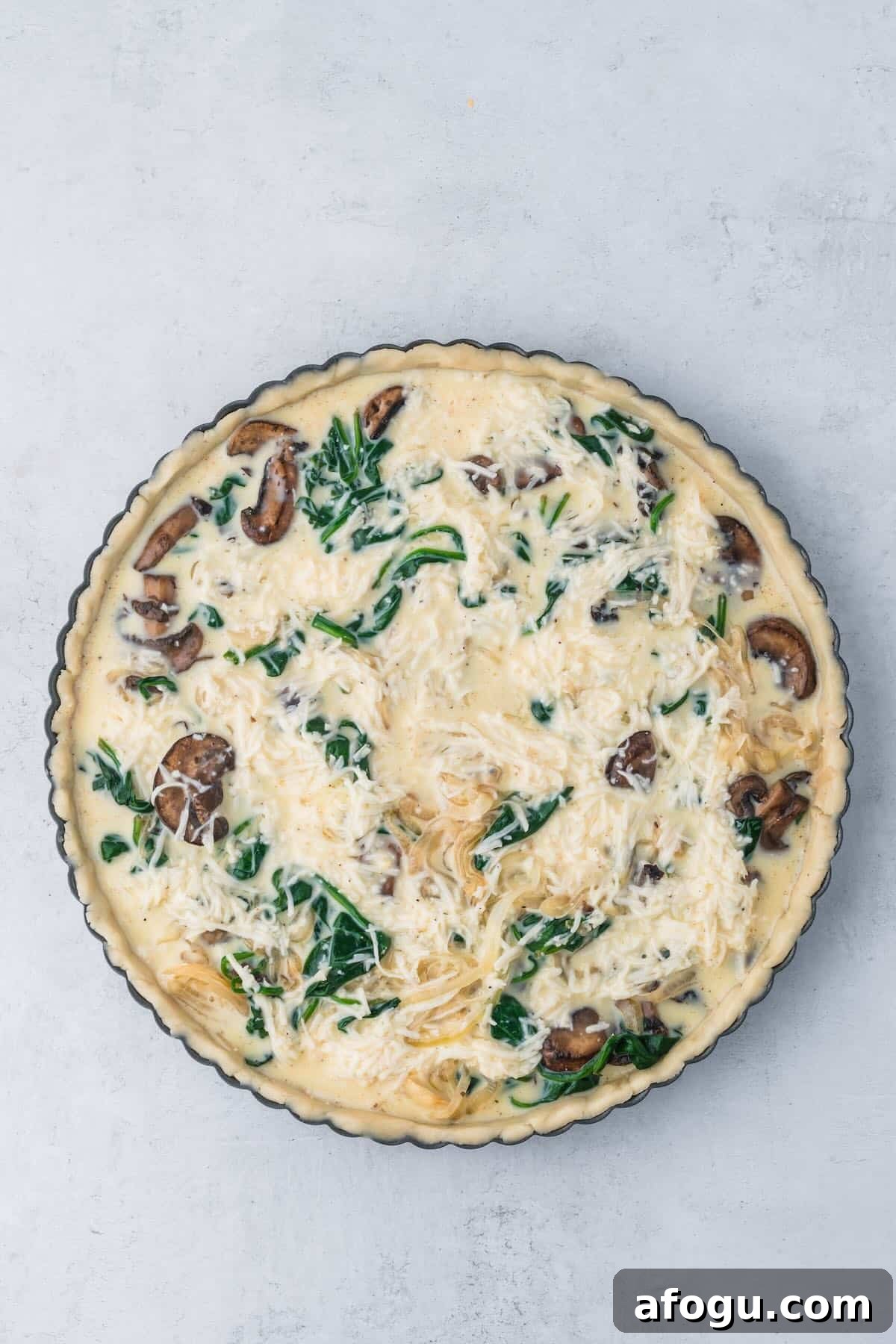 Spinach Mushroom Quiche Recipe — Flaky Crust, Creamy Filling 8 Unbaked spinach and mushroom quiche in a pie crust.
