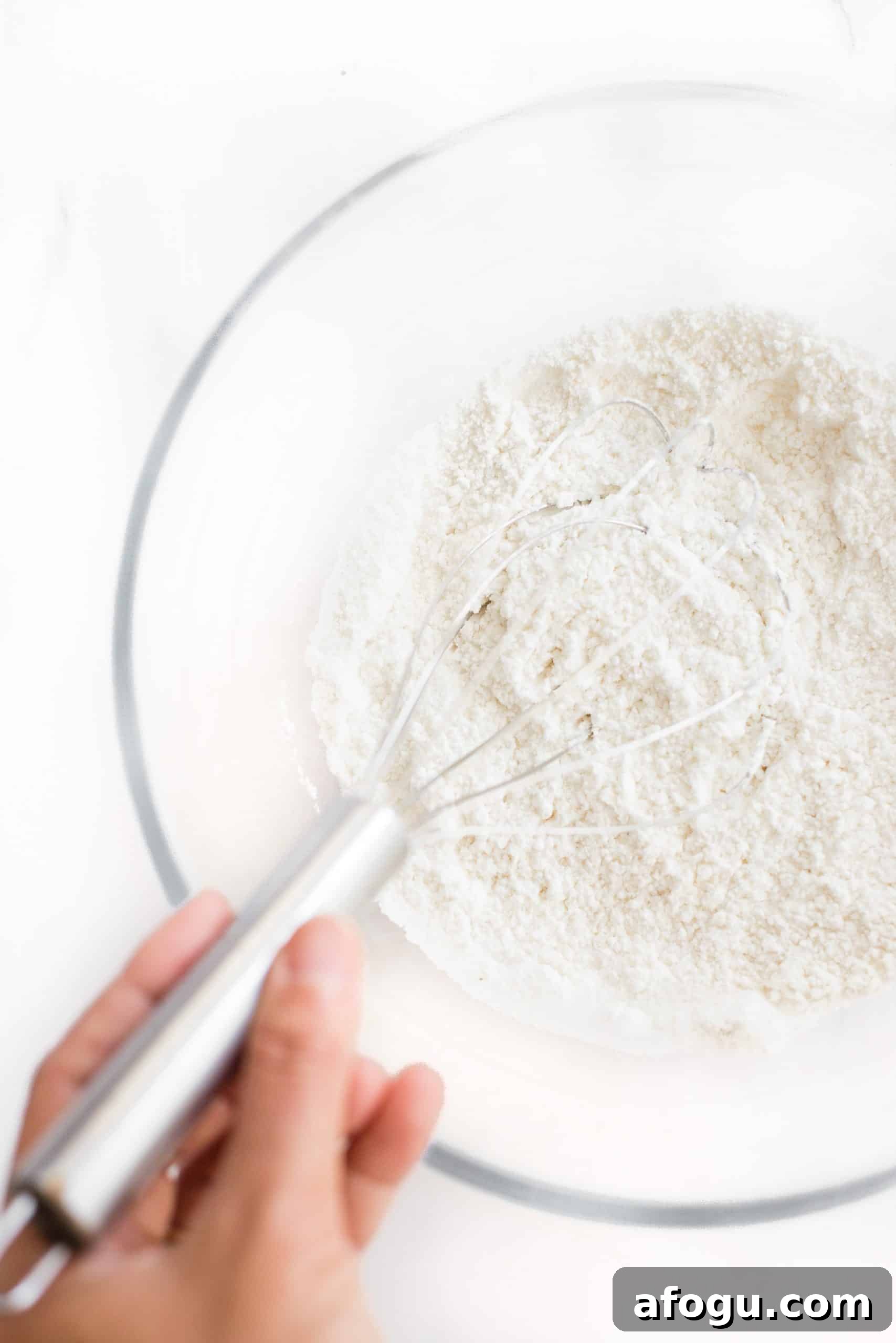 Easy Gluten-Free Peach Cobbler (Dairy-Free, Vegan) Whisking dry ingredients in a large glass bowl.