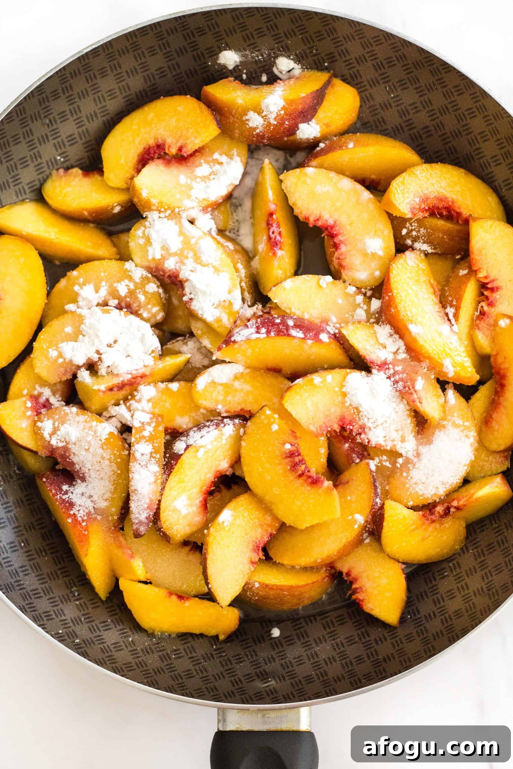Easy Gluten-Free Cobbler Recipe (Dairy-Free, Vegan) Sliced peaches and corn starch in a skillet.