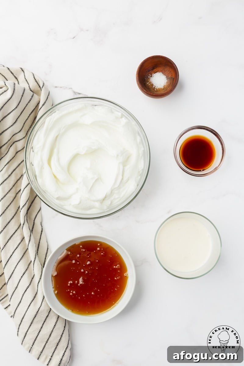 a bowl of green yogurt, a smaller bowl of honey, and three even smaller bowls holding salt, vanilla, and heavy cream. The bowls are arranged on a marble counter, viewed from overhead.