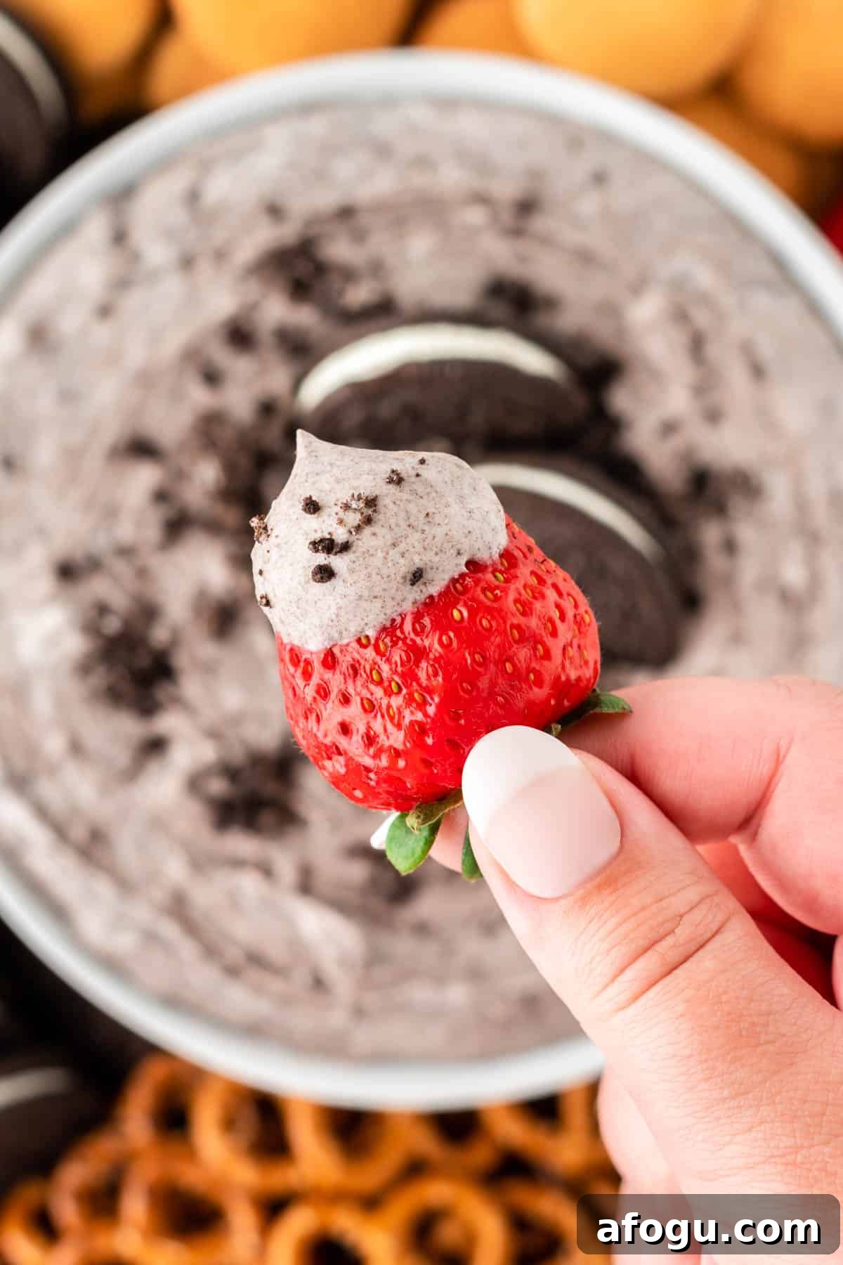 dipping a strawberry into oreo dip