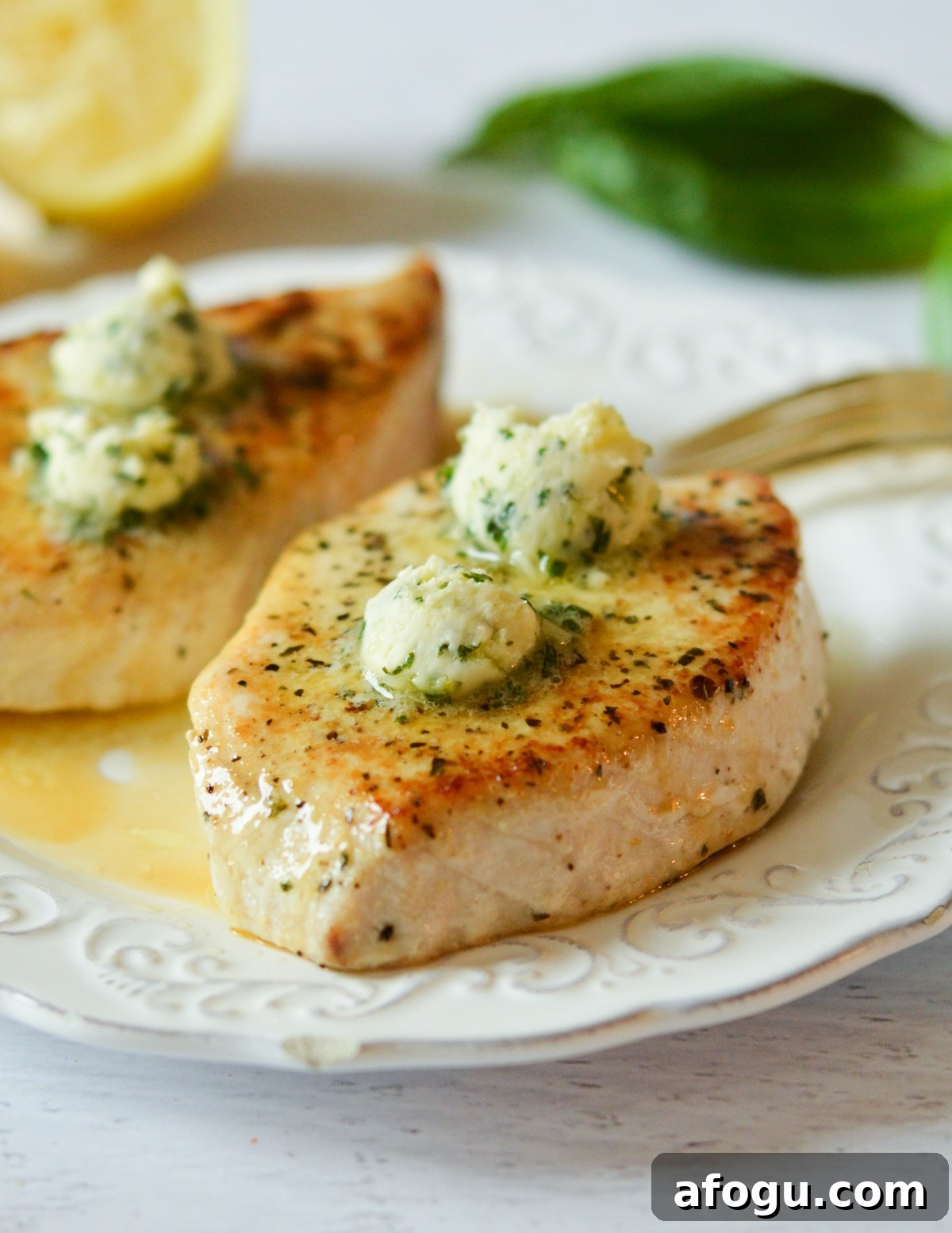 swordfish on a plate with butter on top.