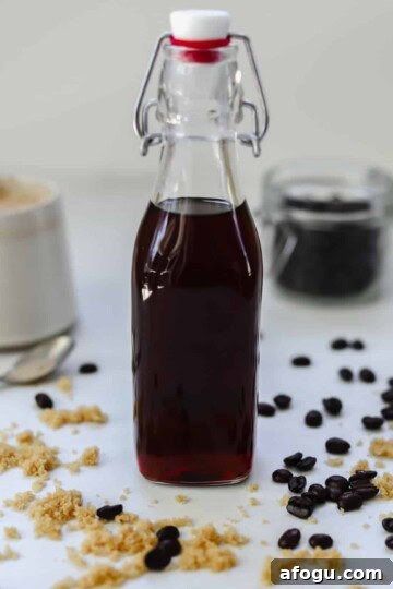 bottle of brown sugar simple syrup with coffee and coffee beans in the background