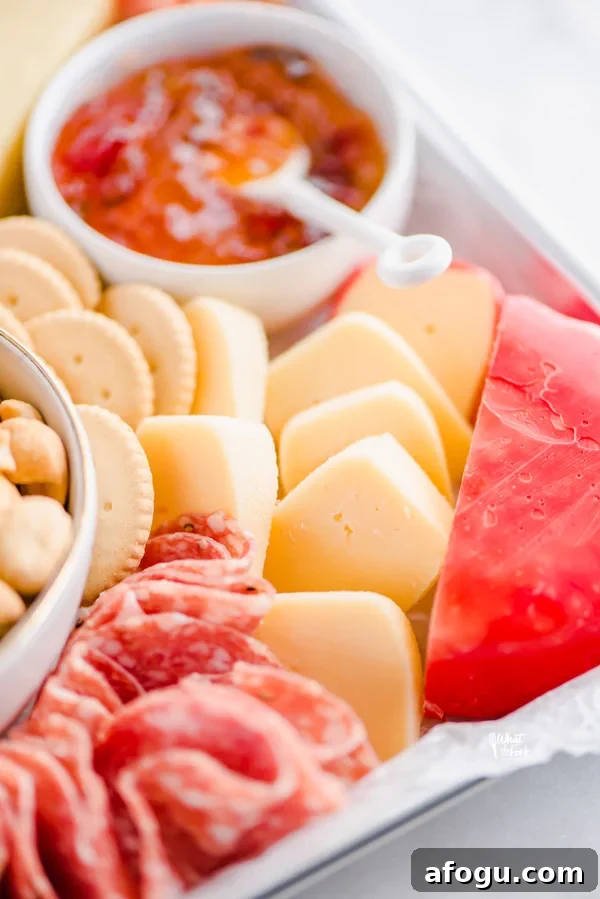 close up shot of gouda cheese cut into wedges surrounded by salami and gluten free crackers
