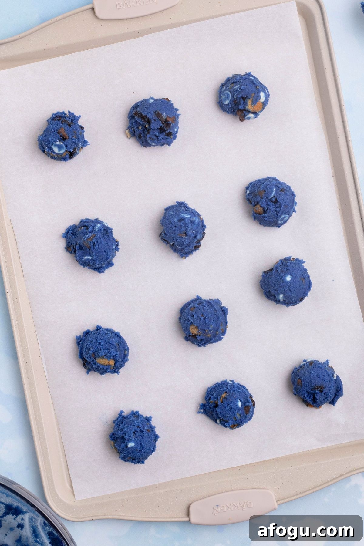 Cookie dough scooped onto a baking sheet lined with parchment paper.