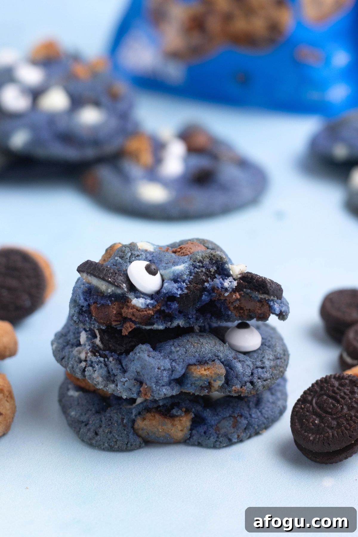 Bright blue cookie monster cookies stacked on a blue table.
