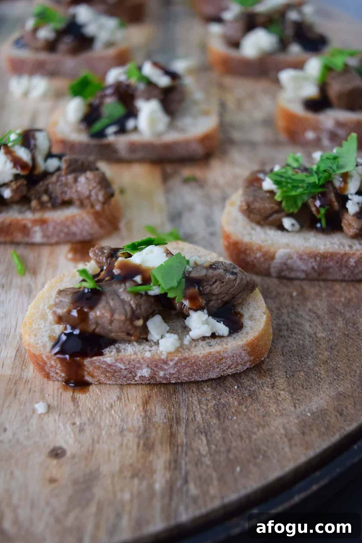 Blue Cheese and Steak Crostini on wooden platter close up view
