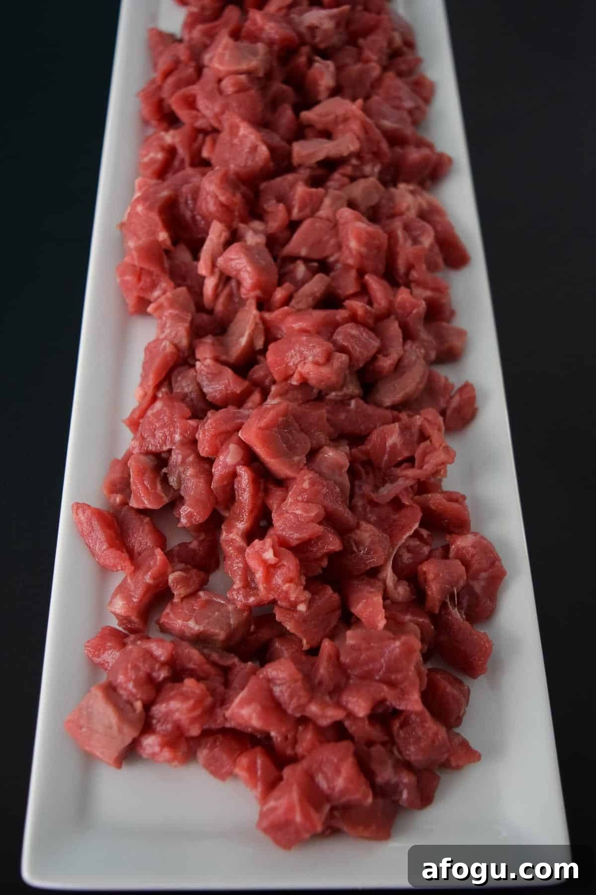 Raw beef stroganoff on white platter