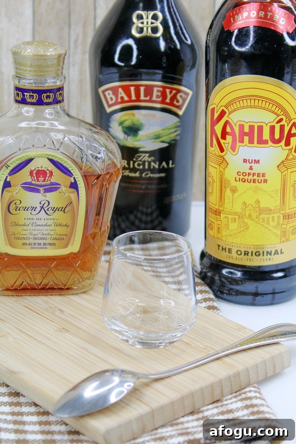 crown royal whiskey, baileys Irish cream, Kahlua coffee liqueur, and an empty glass. 
