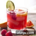 For an easy summer cocktail, try a raspberry orange margarita! Limes, orange juice, raspberry syrup, and triple sec on the rocks. Great for Cinco de Mayo, as for Valentine's, or as an anytime drink! | justalittlebitofbacon.com #summerrecipes #cocktails #drinks #margaritas #valentines #cincodemayo