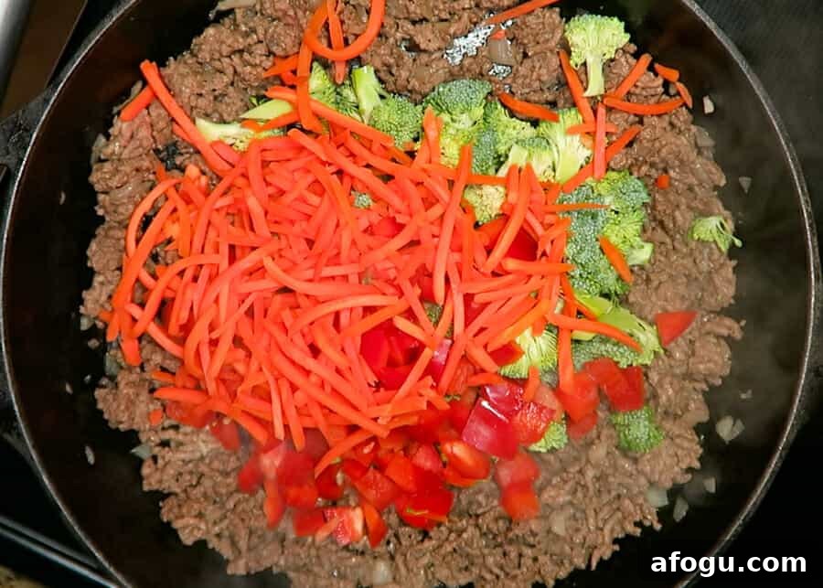 veggies being added to the skillet 