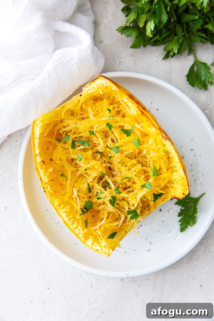 air fryer cooked spaghetti squash on a white plate with parsley and white napkin