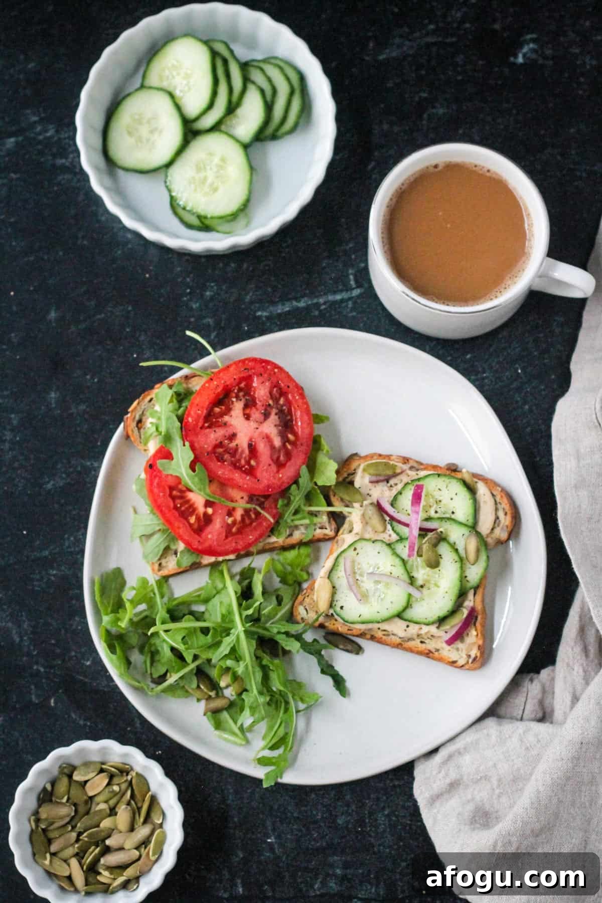 10 Creative Hummus Toast Recipes for Quick Snacks 2 Two pieces of hummus toast on a plate next to a cup of coffee.