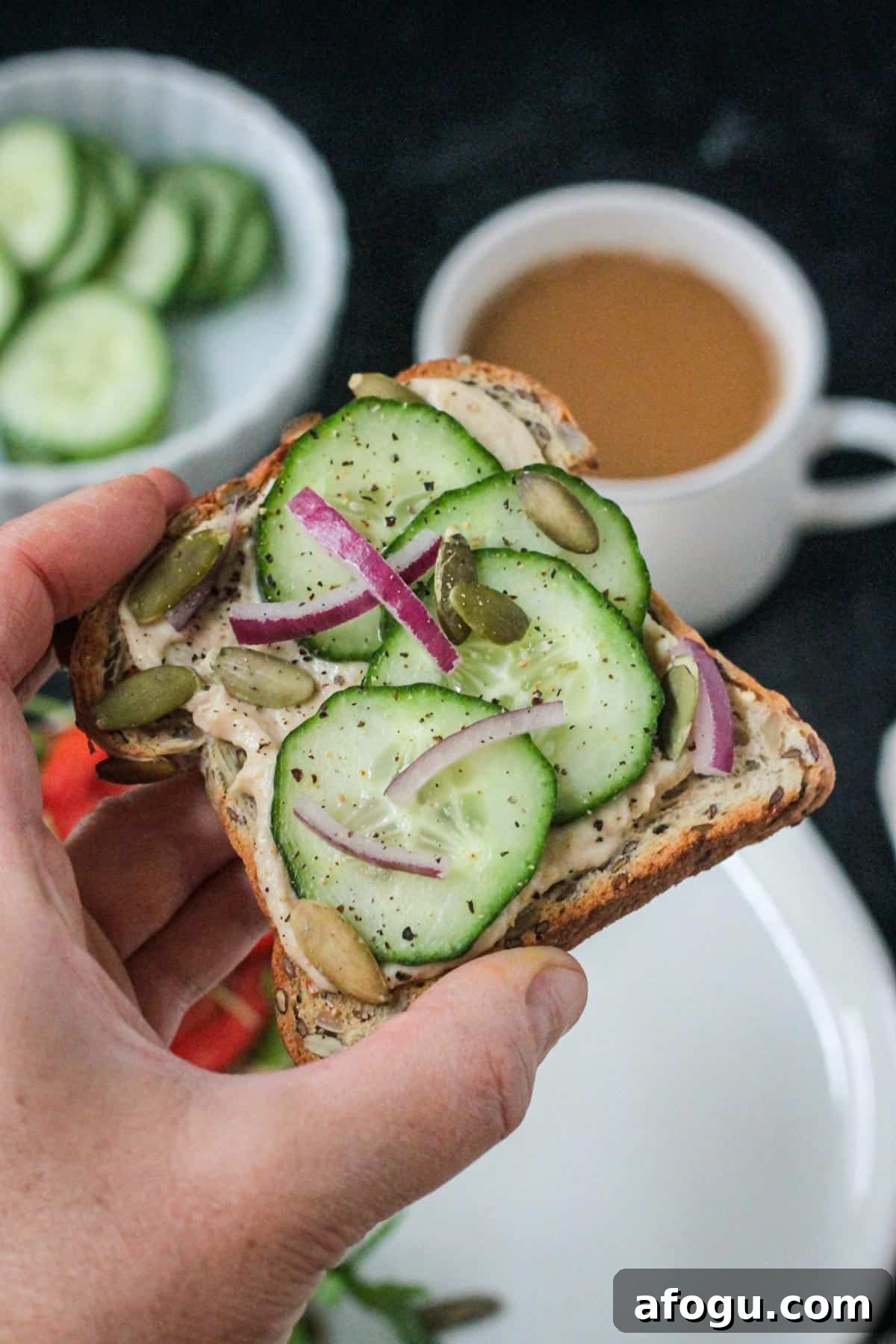 10 Creative Hummus Toast Recipes for Quick Snacks 11 Hand holding a piece of hummus toast.