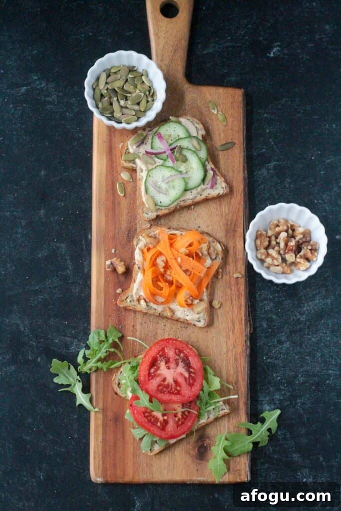 10 Creative Hummus Toast Recipes for Quick Snacks 7 Cucumber hummus toast, carrot hummus toast, and tomato hummus toast on a serving board.