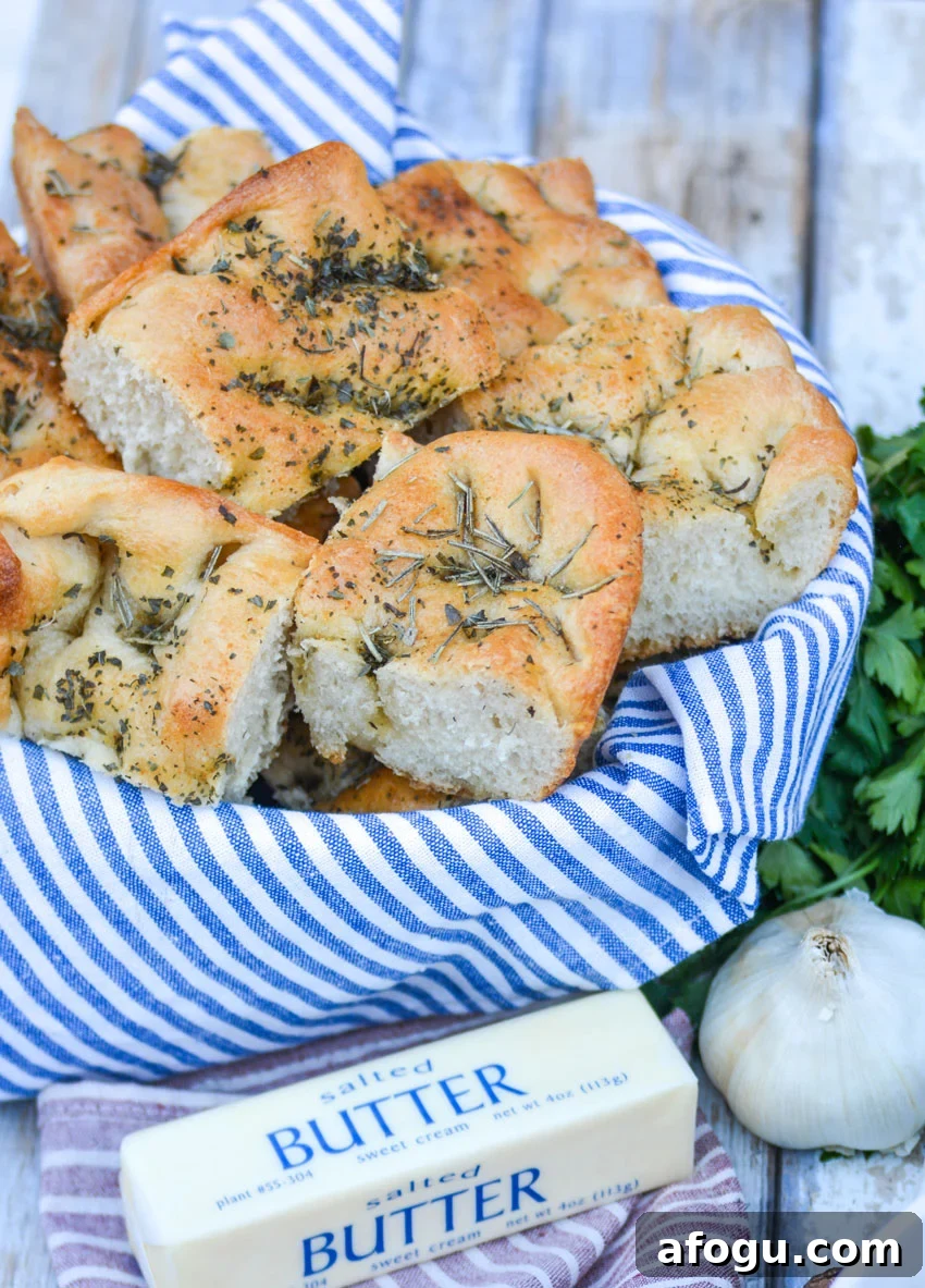 shortcut focaccia bread cut into pieces and stacked in a blue cloth lined bread basket