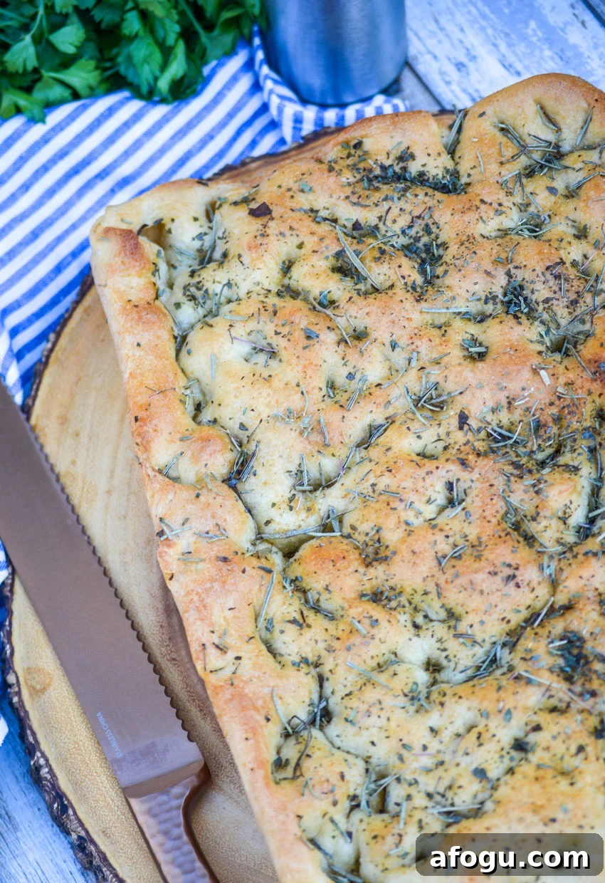 quick and easy focaccia bread topped with rosemary on a wooden cutting board