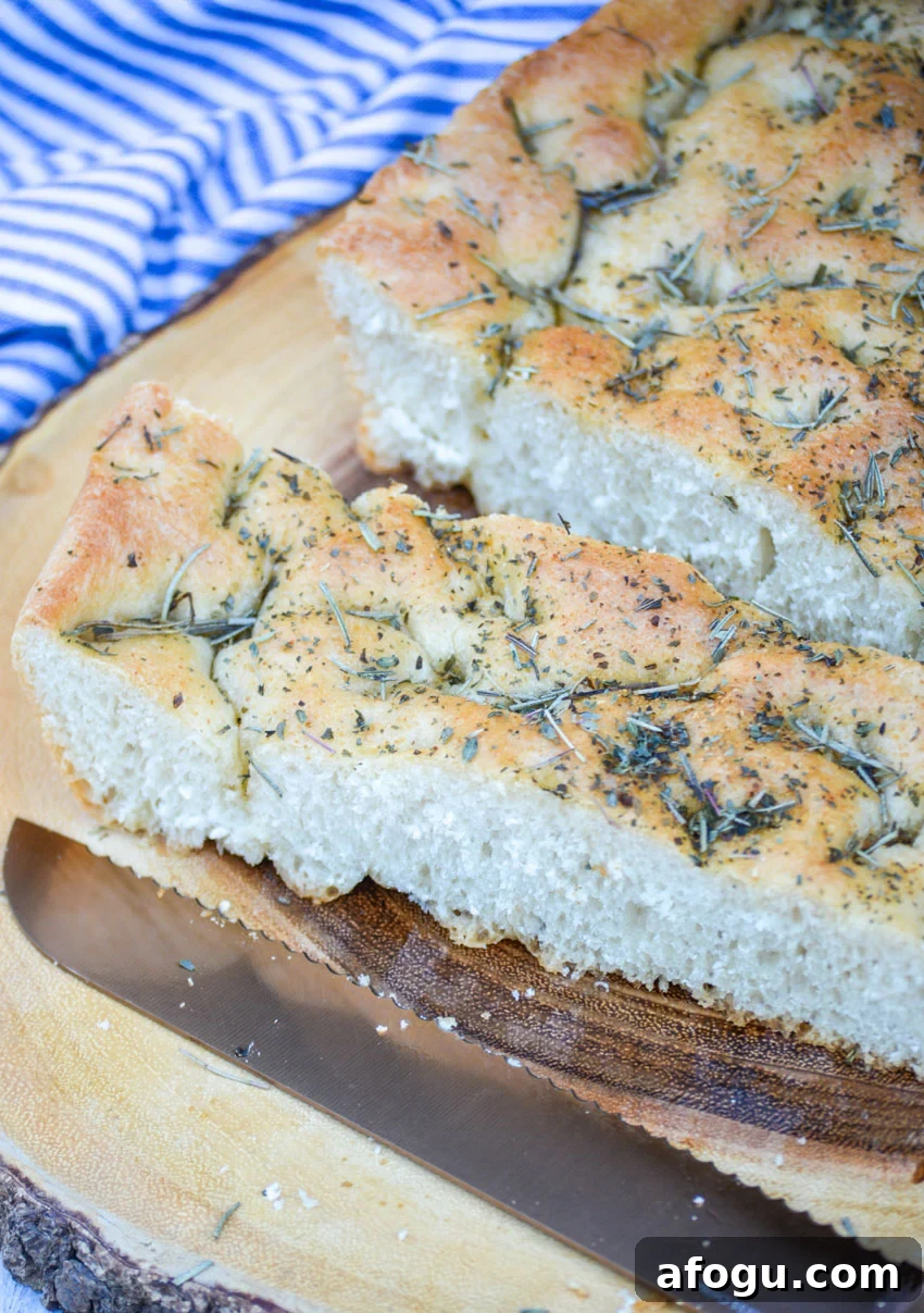 quick and easy focaccia bread topped with rosemary on a wooden cutting board