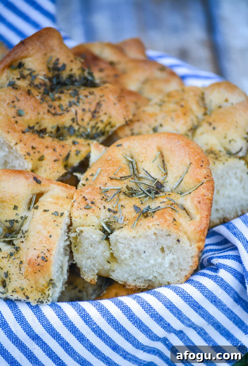 shortcut focaccia bread cut into pieces and stacked in a blue cloth lined bread basket