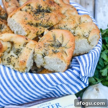 shortcut focaccia bread cut into pieces and stacked in a blue cloth lined bread basket