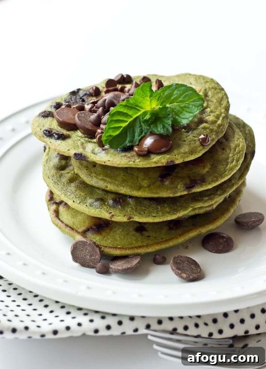 Child smiling at breakfast with green pancakes