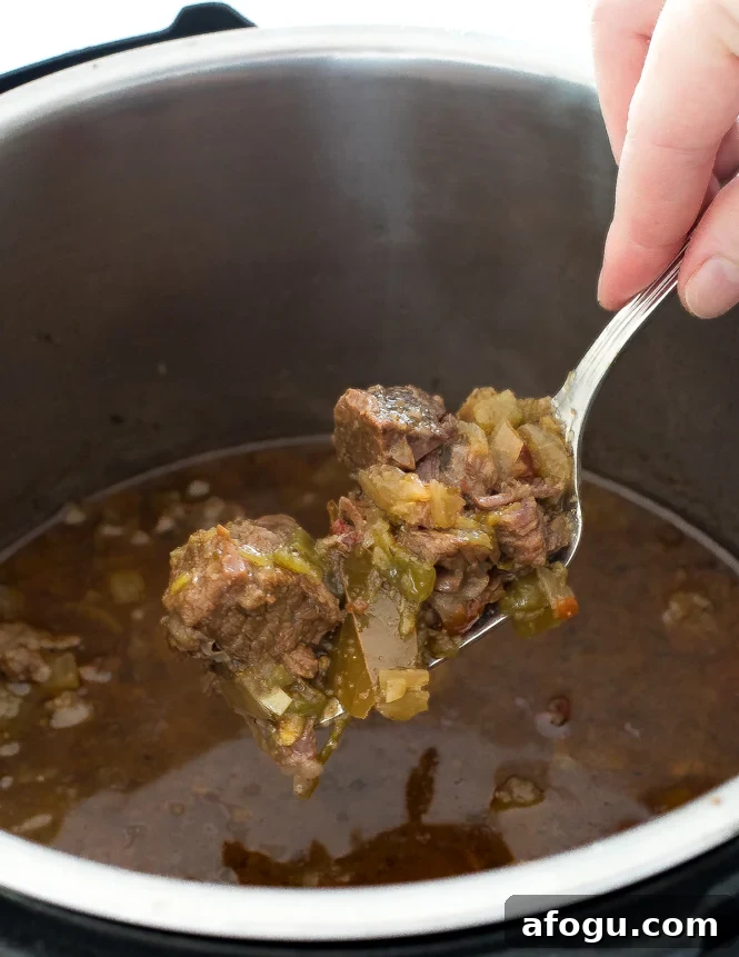 scooping shredded Barbacoa beef out of the Instant Pot