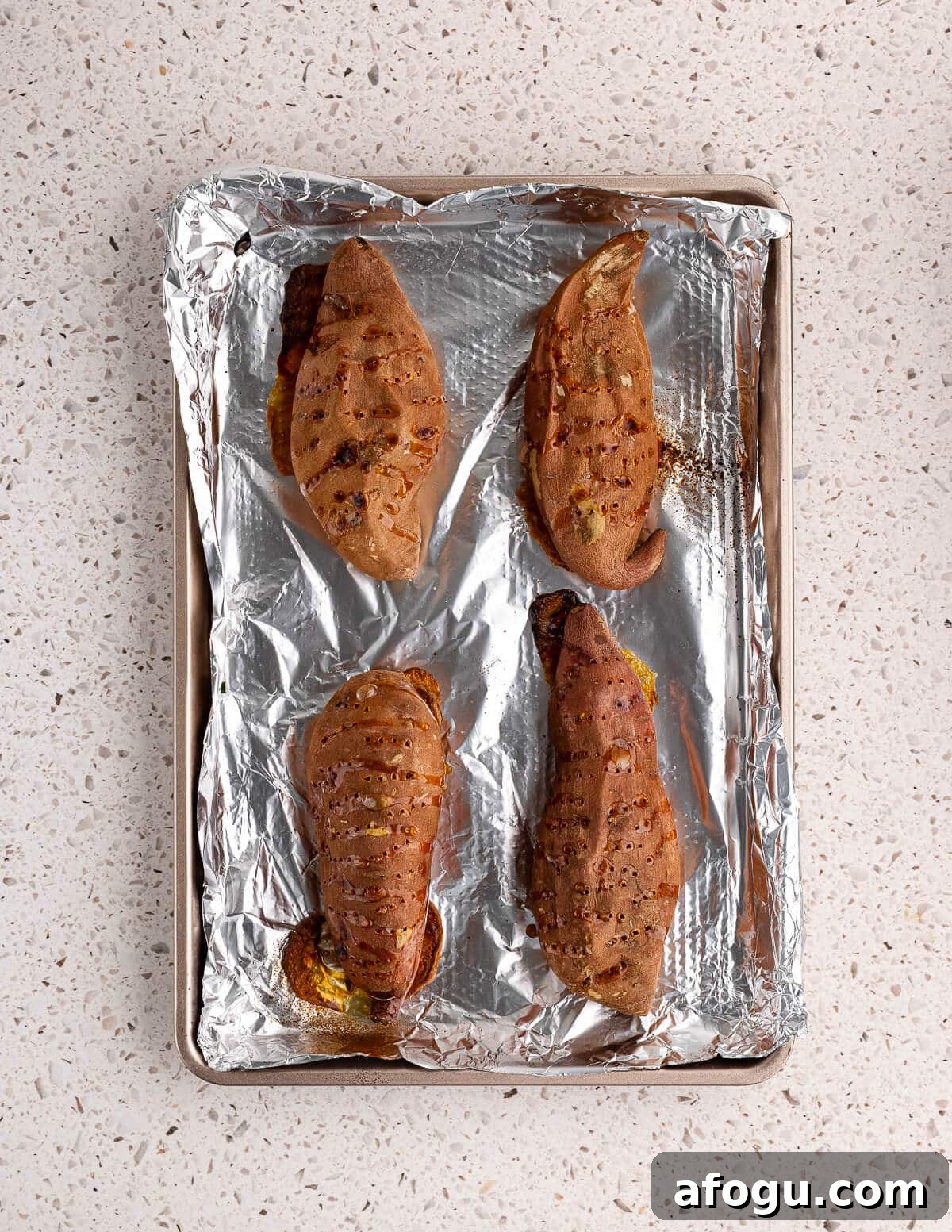 baked sweet potatoes on an aluminum foil lined sheet pan. 