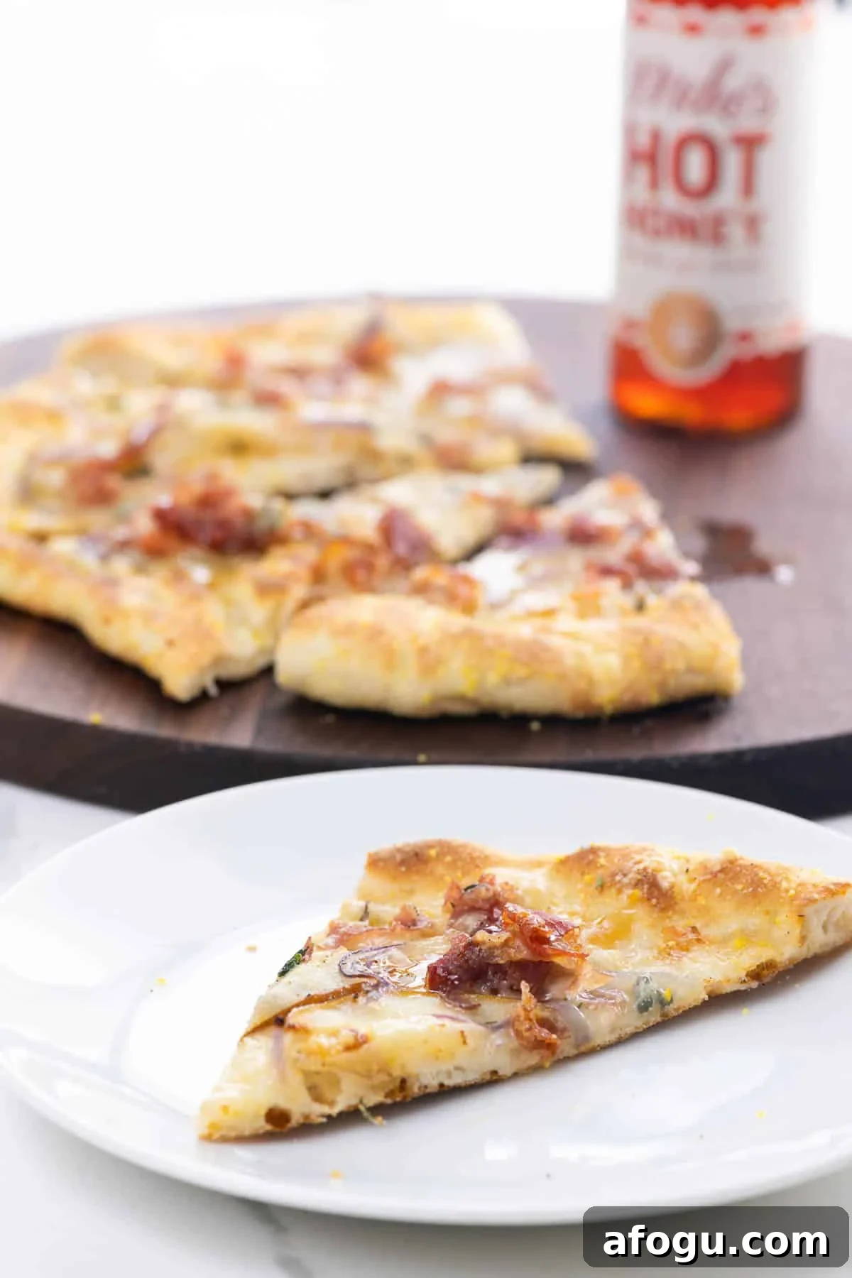 Pear and Gorgonzola Pizza Recipe with Honey and Walnuts 5 pear gorgonzola pizza with prosciutto and hot honey on a cutting board and a plate