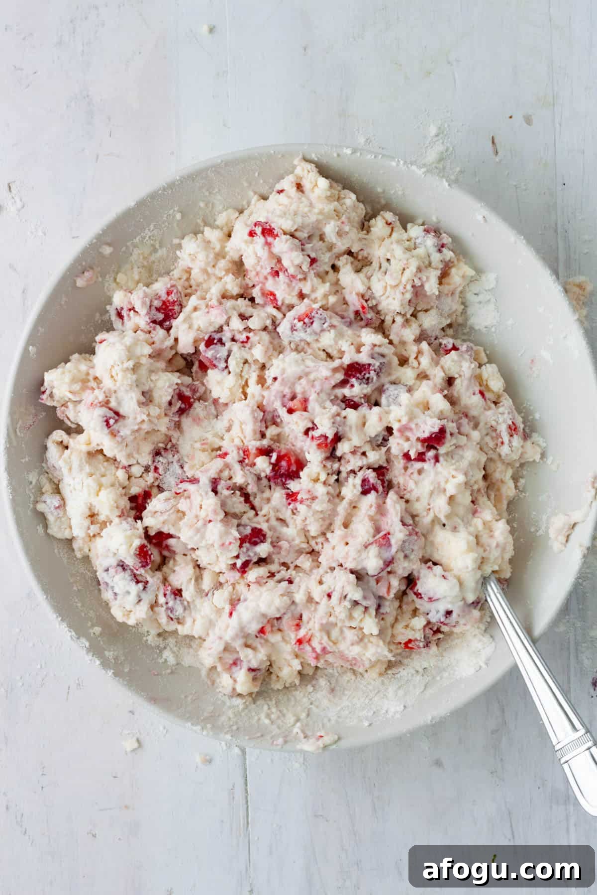 Strawberry biscuit dough in a medium mixing bowl.