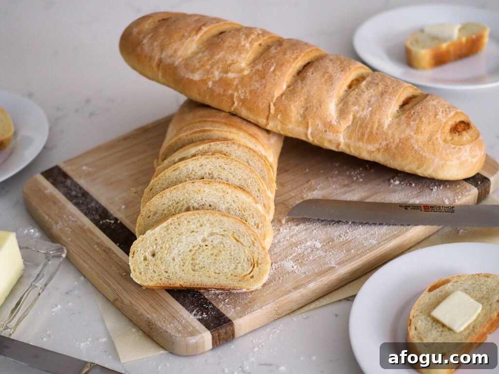 Completed loaves, with one sliced and facing the camera. Another full loaf rests on top of it at a diagonal.