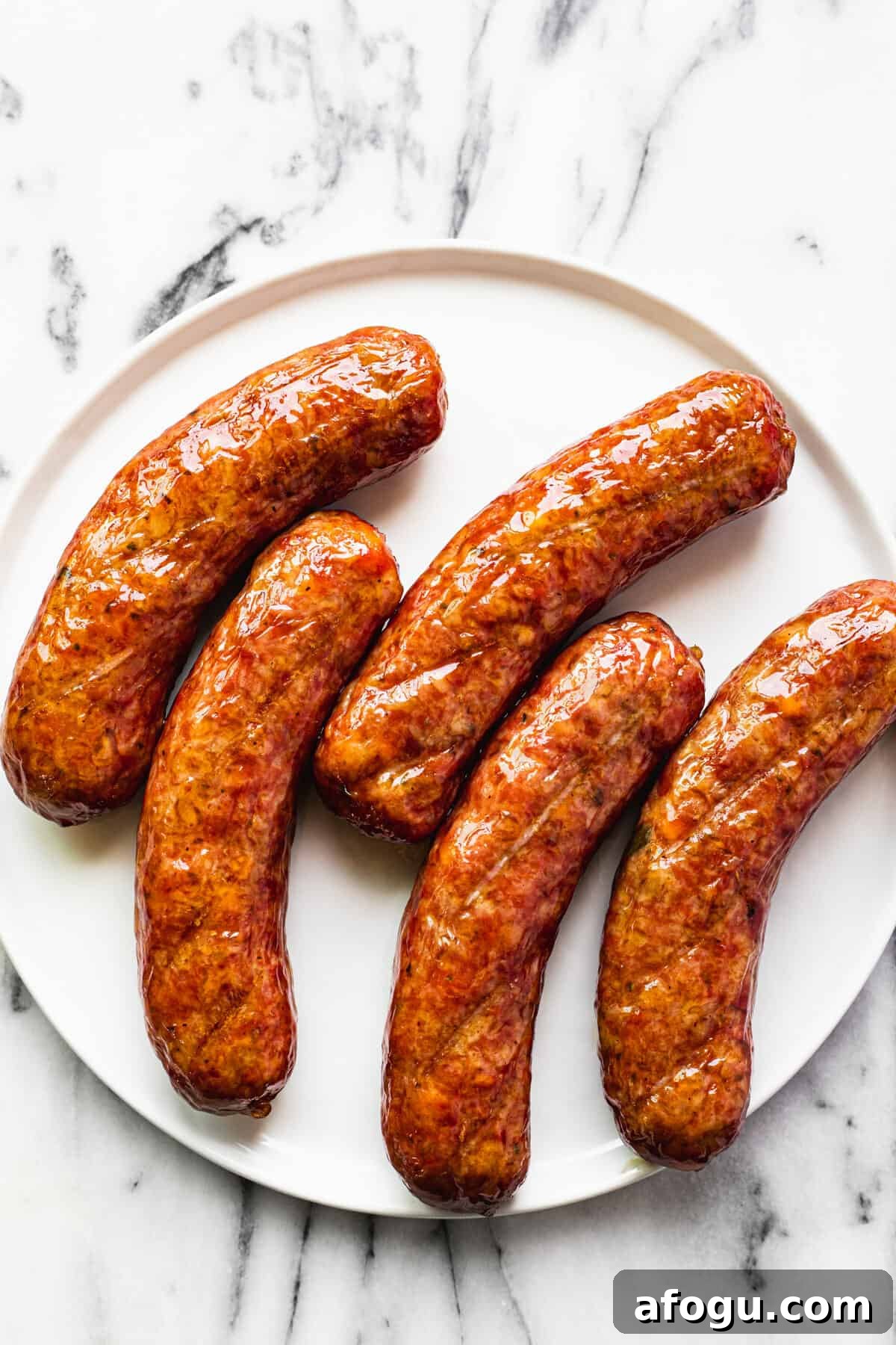 White plate filled with 5 smoked sausages.