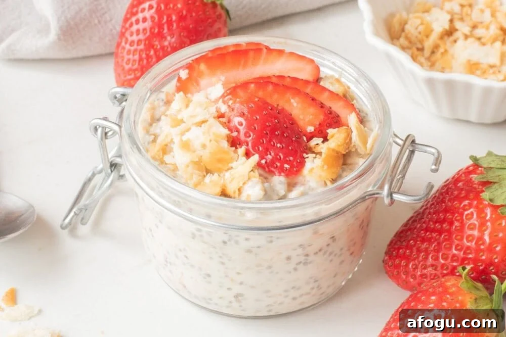 Strawberry Cheesecake Overnight Oats Recipe for Creamy Make-Ahead Breakfast 8 Strawberry cheesecake overnight oats in a glass jar topped with sliced strawberries and graham cracker crumbs.