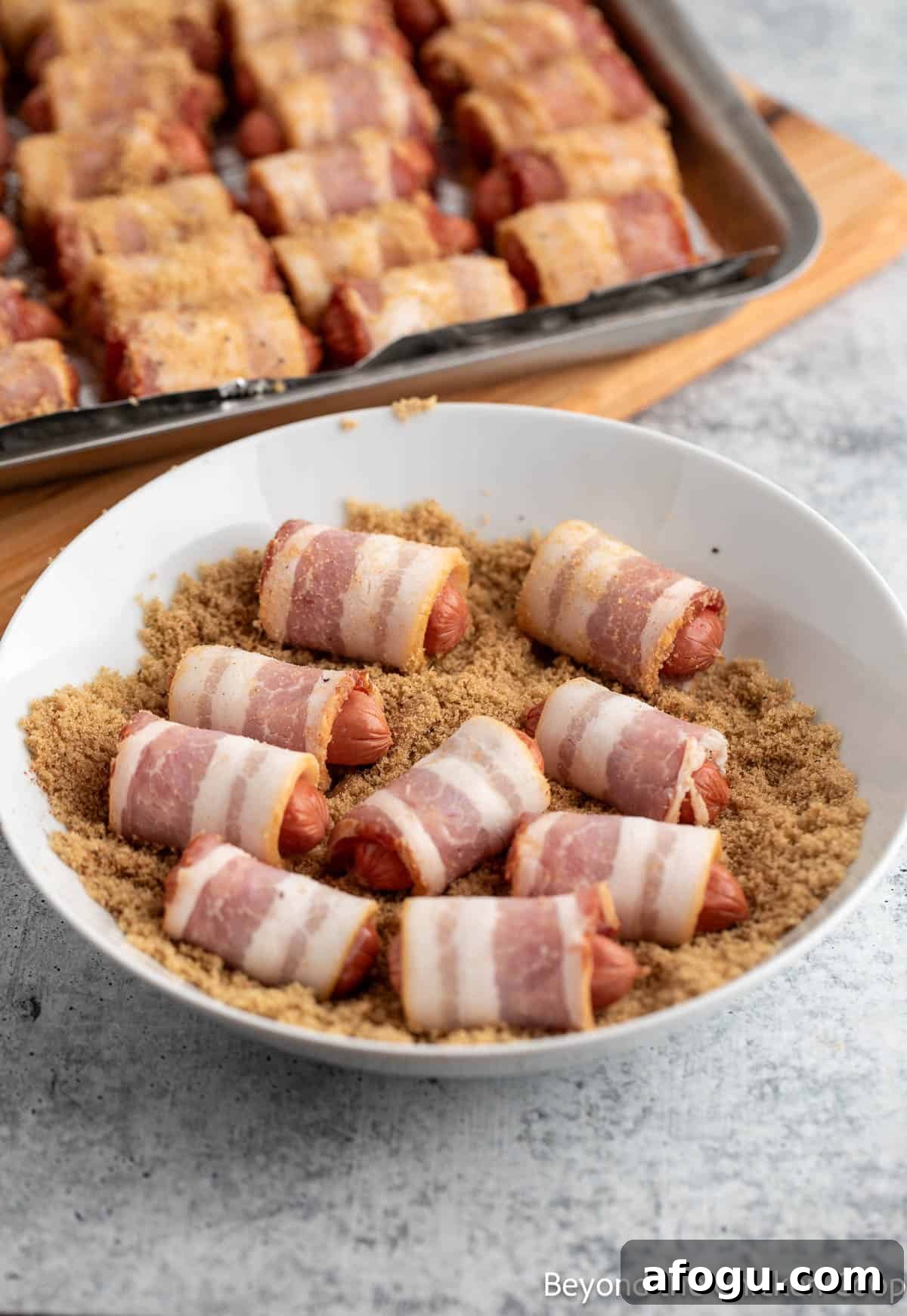 Bacon wrapped smokies in a bowl of brown sugar.