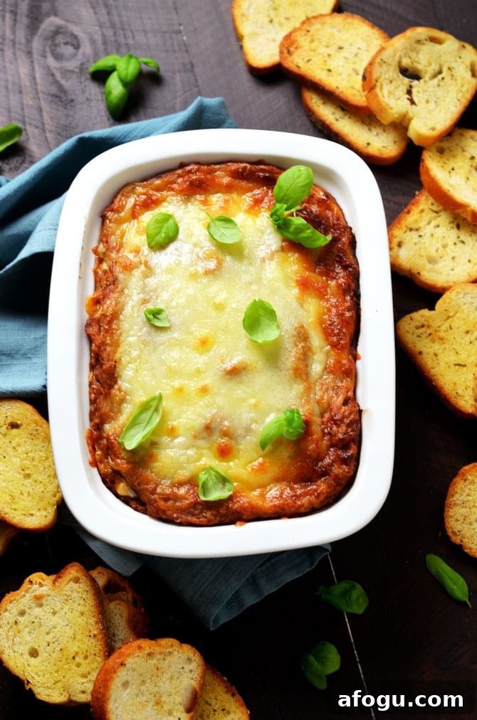 Eggplant Parmesan Dip. This warm, cheesy dip is loaded up with tomato sauce, garlic, and roasted eggplant. I love making it for winter parties. | hostthetoast.com