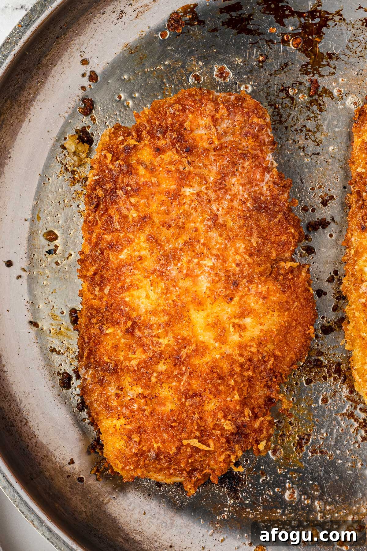 Crispy Panko Chicken with Dijon Mustard and Parmesan 6 An overhead closeup view of crispy panko chicken cooked in a pan.