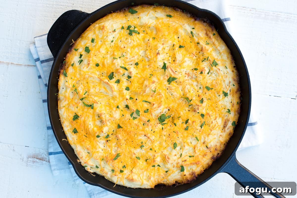 Skillet sheperd's pie topped with mashed potatoes in a cast iron skillet.