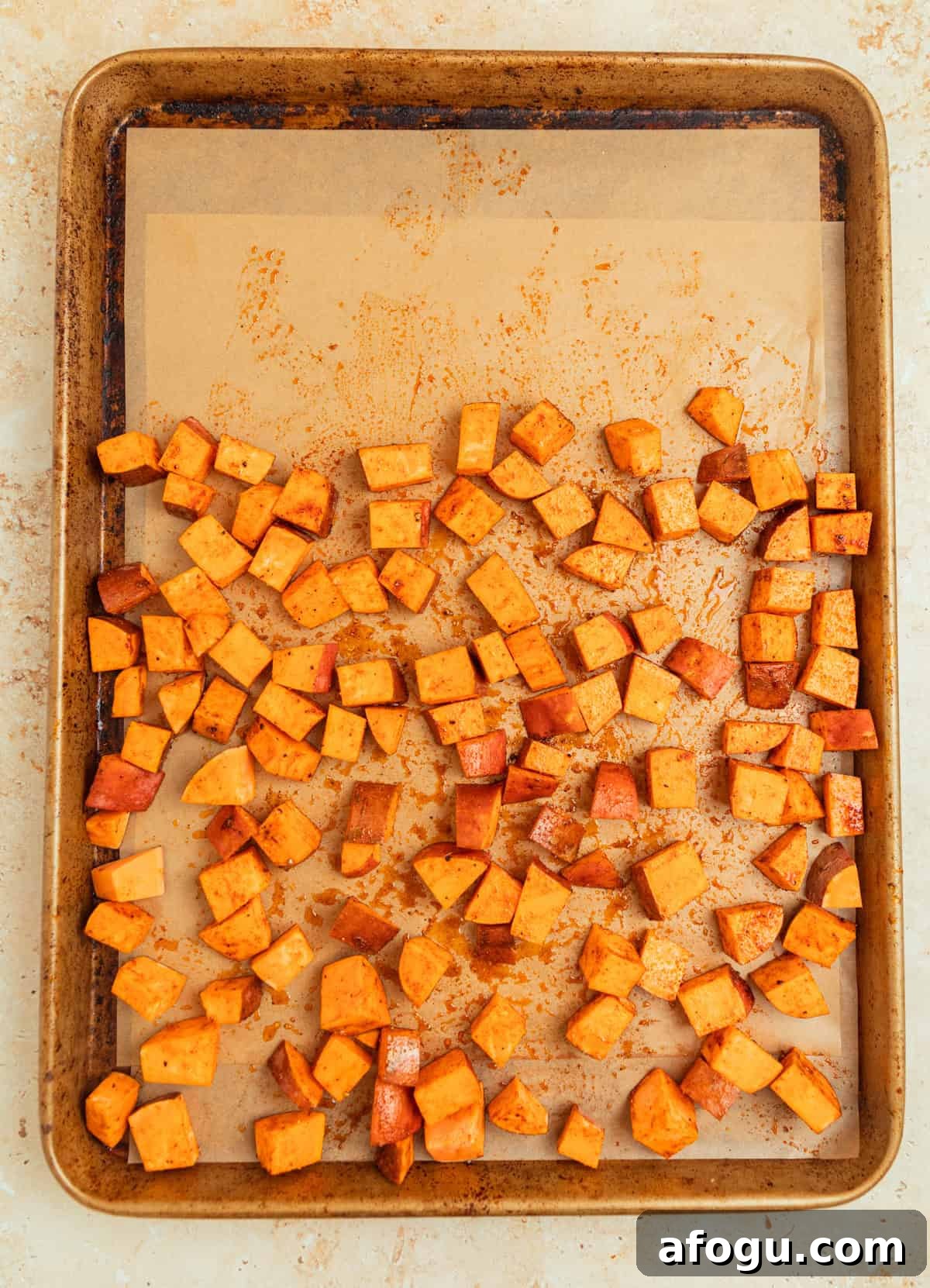 Sweet potatoes on baking sheet with parchment paper.