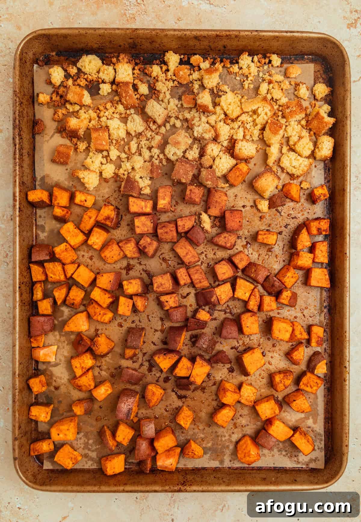 Sheet pan with roasted sweet potatoes and cornbread croutons.