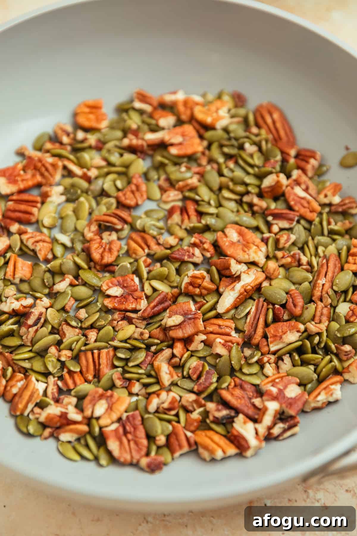 Toasted pecans and pepitas in skillet.