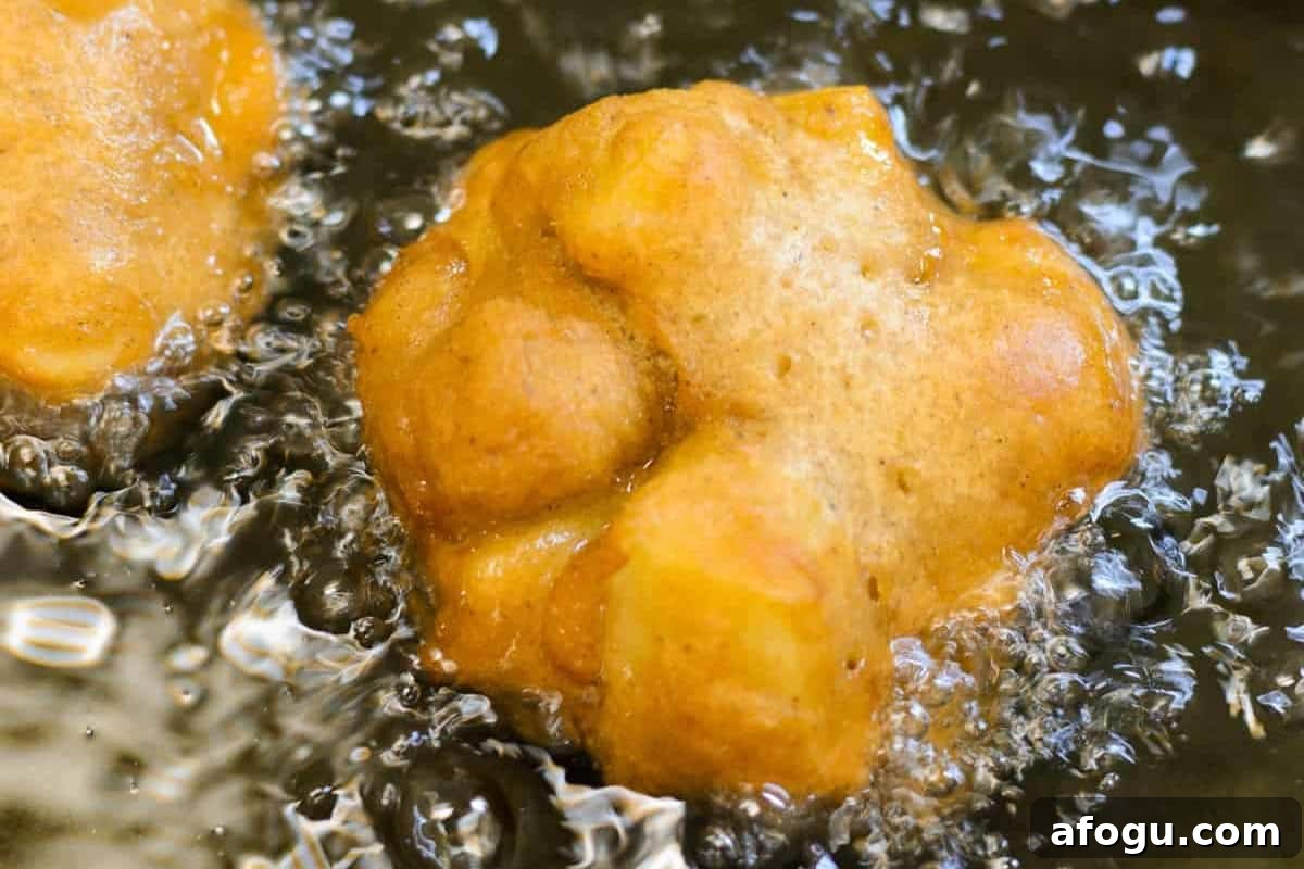 frying apple fritters in hot oil.