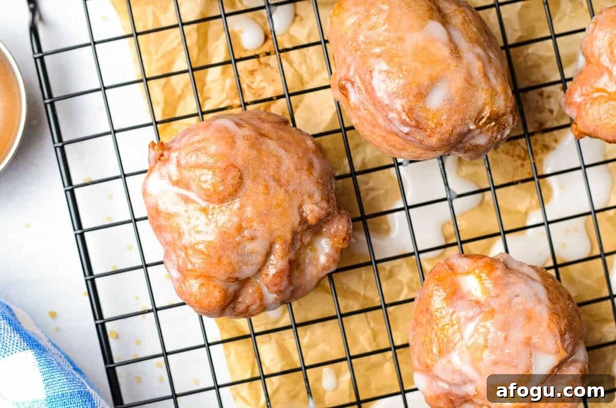 fried apple fritters on cooling rack.