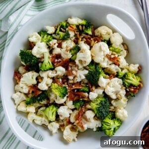 Broccoli and cauliflower salad in a white serving bowl.