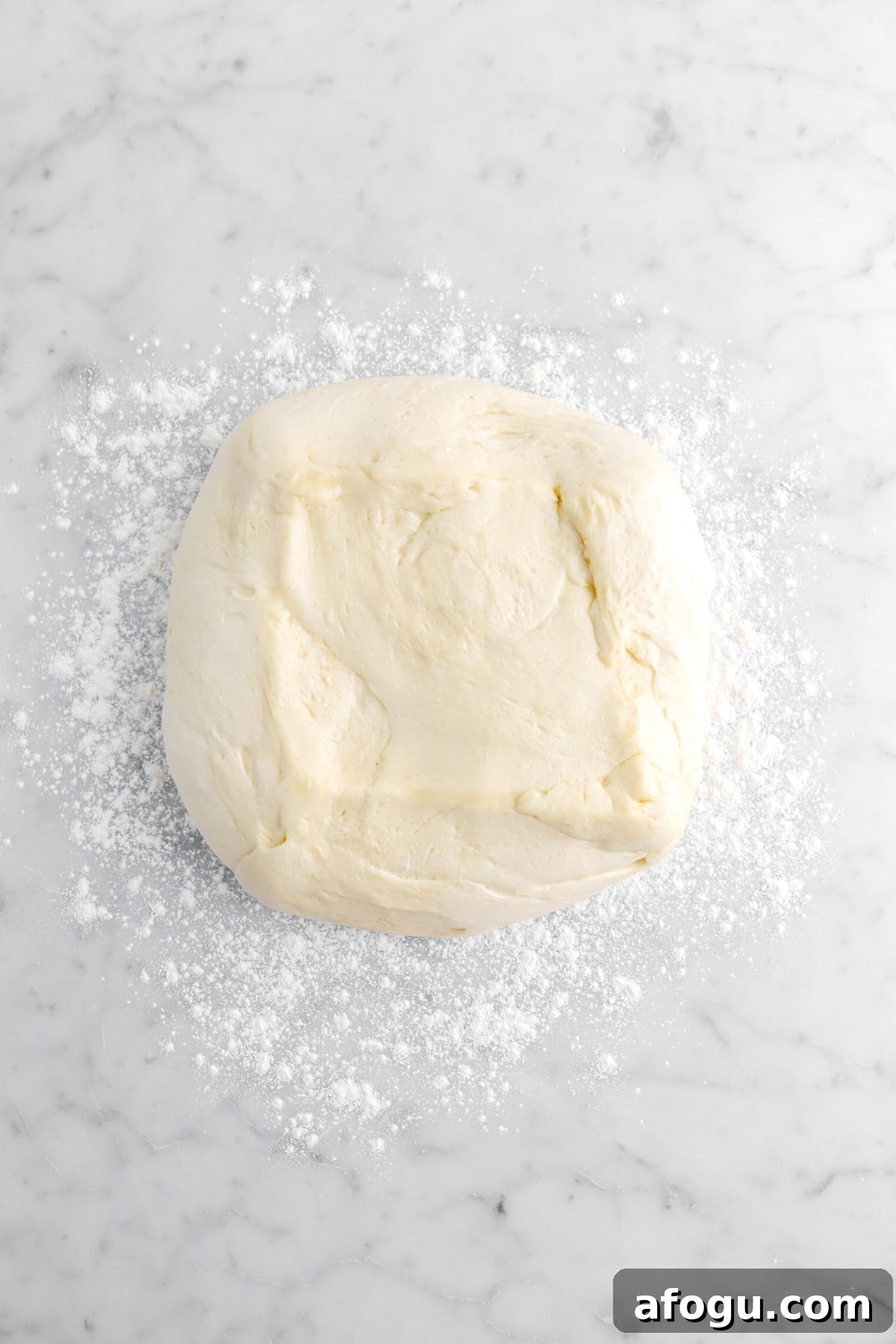 proved dough on floured marble surface.
