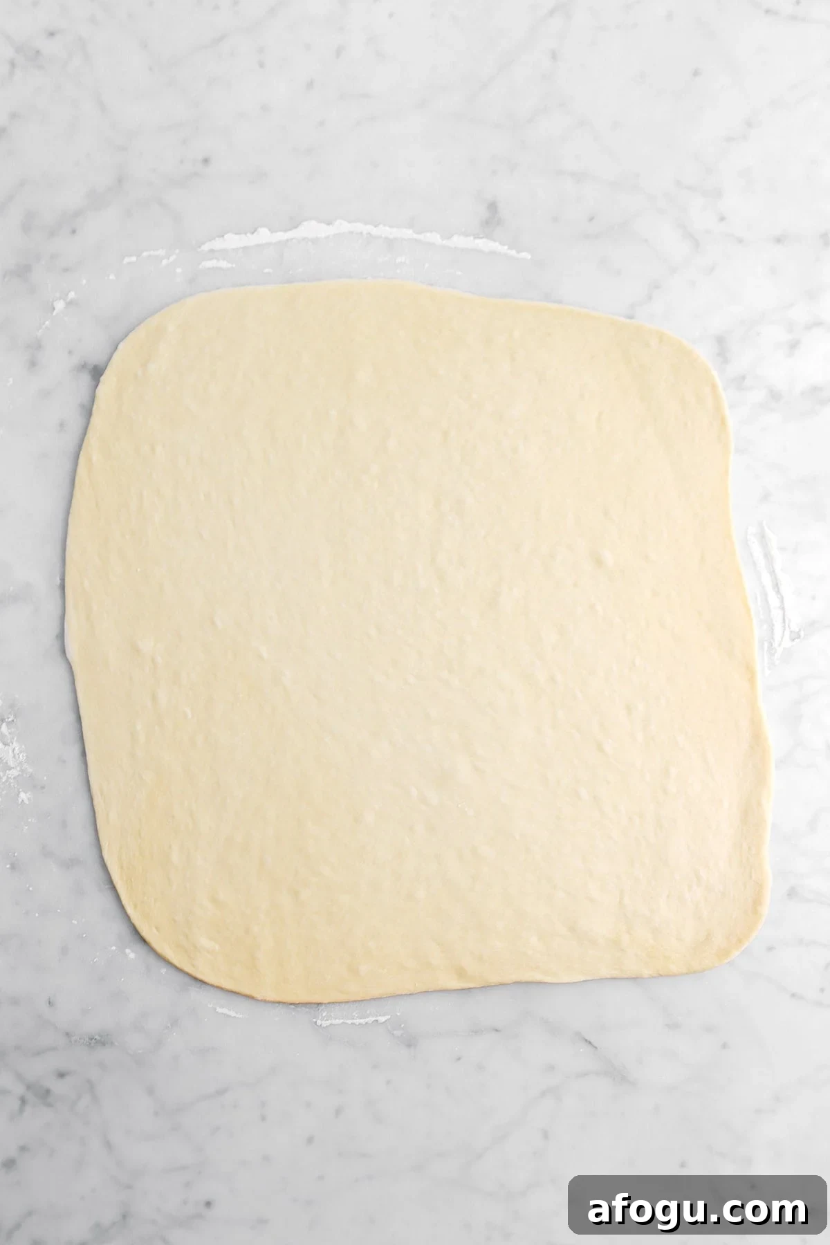 rolled out dough on marble surface.