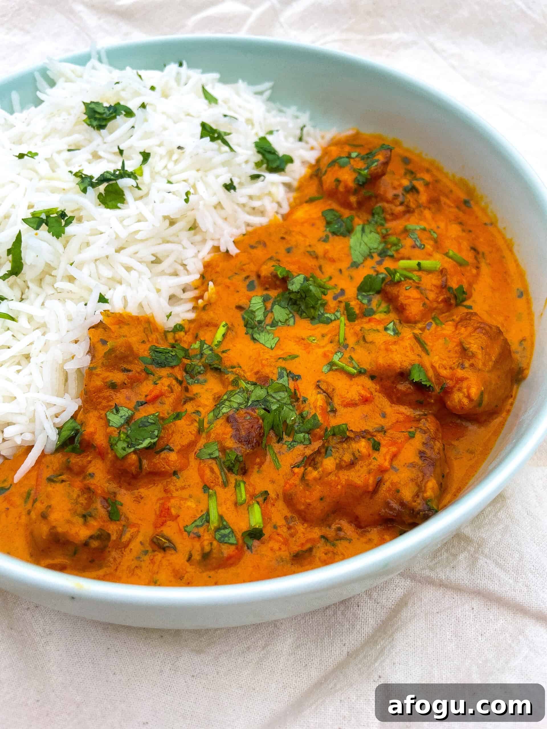 A bowl of white rice and butter chicken
