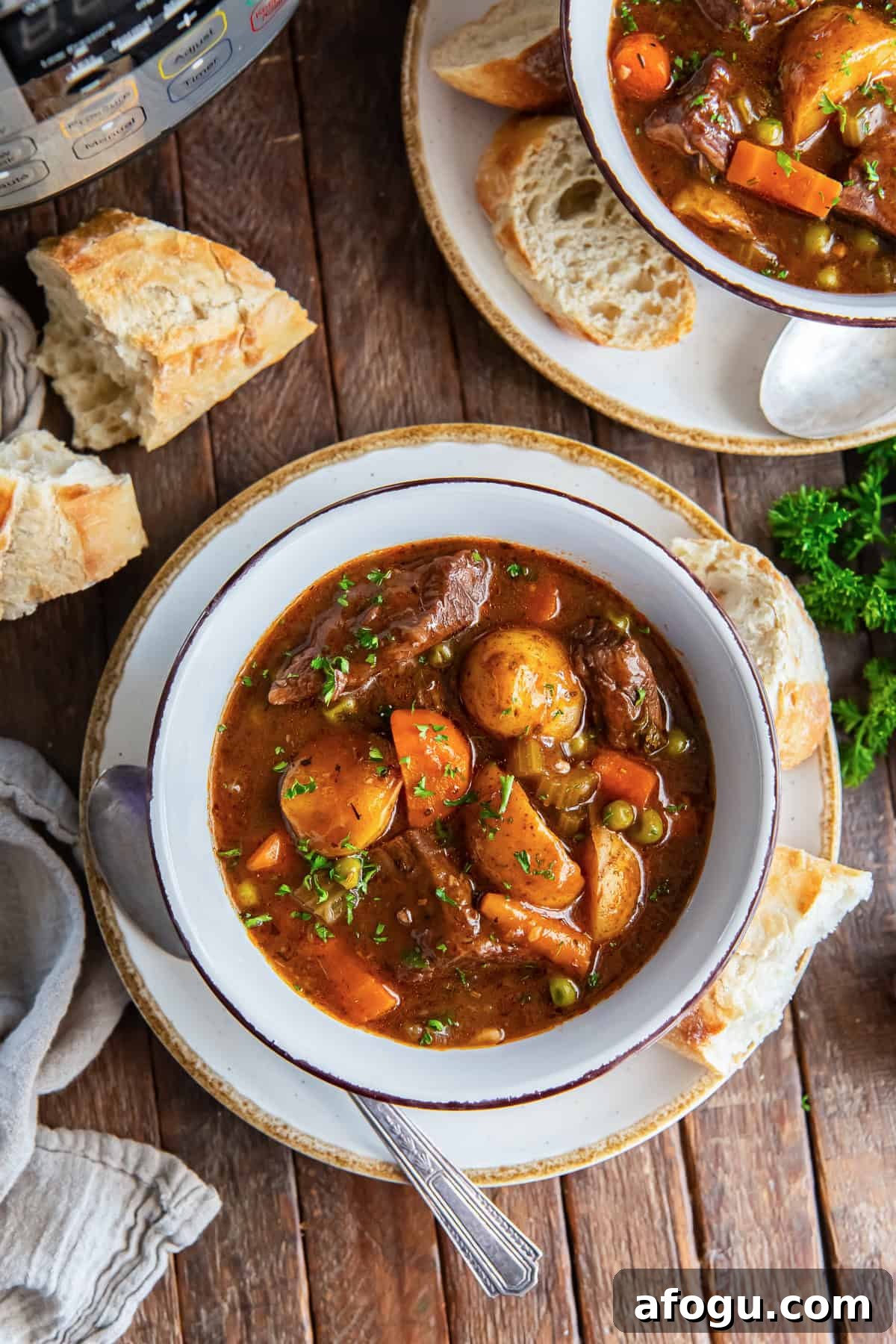 Two bowls of beef stew next to an Instant Pot.