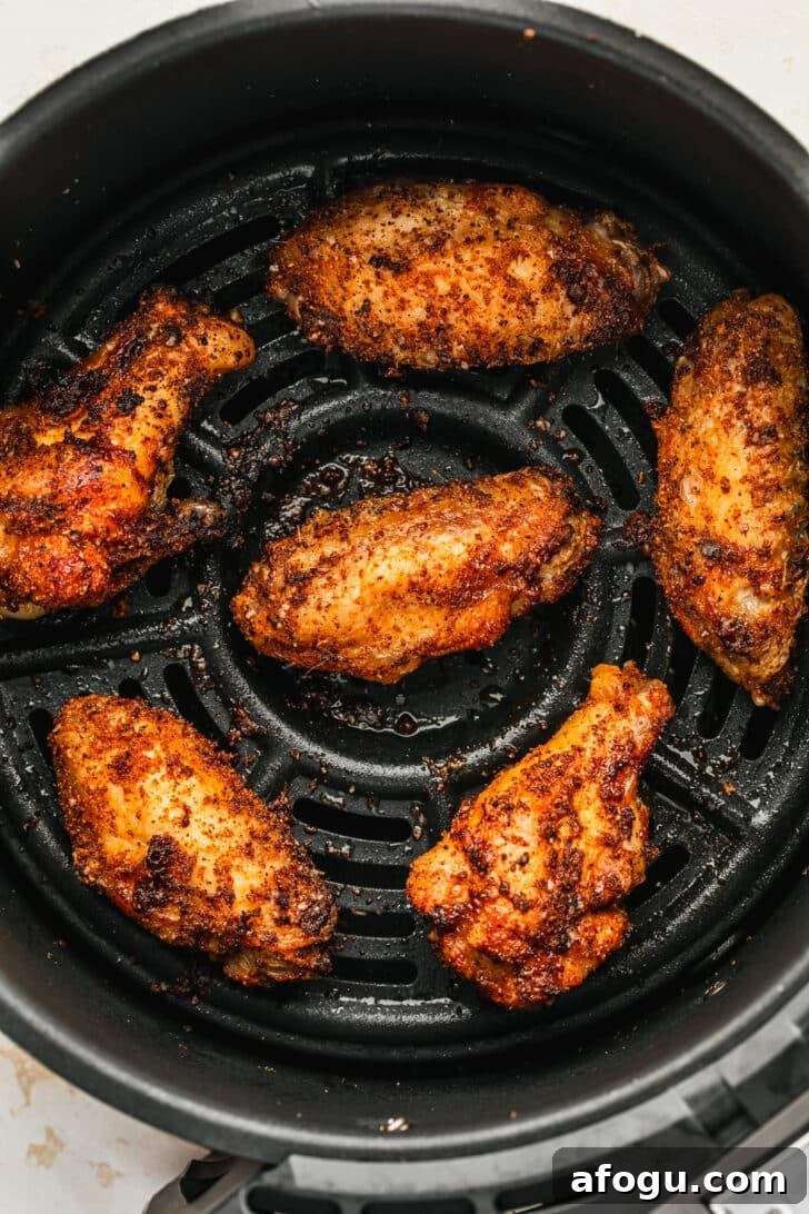 Crispy Dry-Rub Chicken Wings — Oven or Air Fryer Recipes 7 Crispy dry rub chicken wings in an air fryer basket.