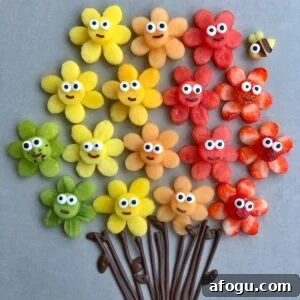 Elegant Fruit Platter Ideas for Special Occasions 7 An arrangement of colorful fruit slices shaped like flowers with cartoon faces and chocolate stems. A mango bee is seen in the background.
