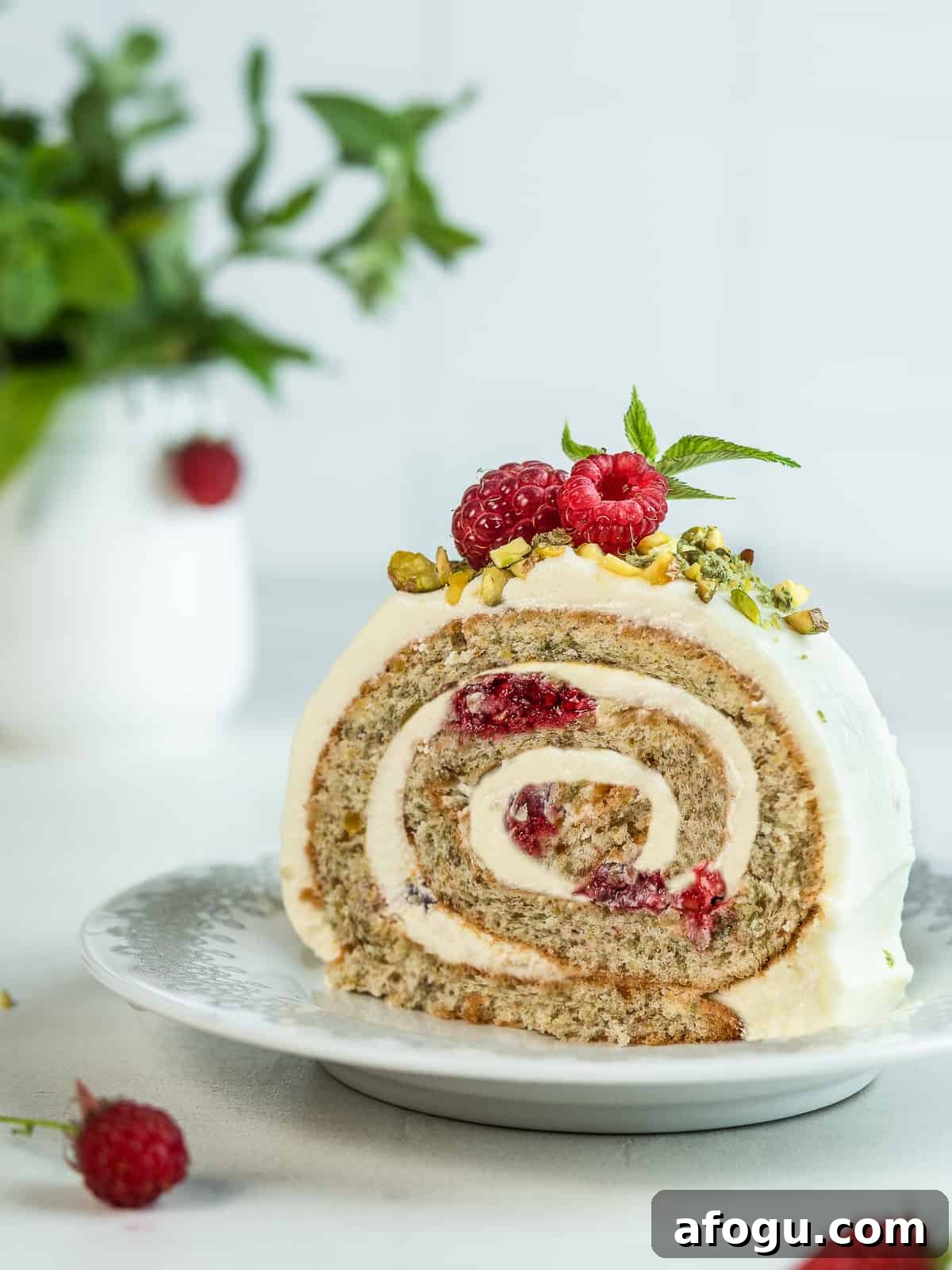 A slice of pistachio roll cake on a white dessert plate 