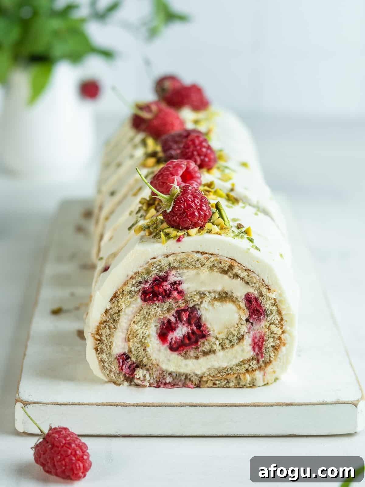 Sliced pistachio roll cake on a white serving platter 